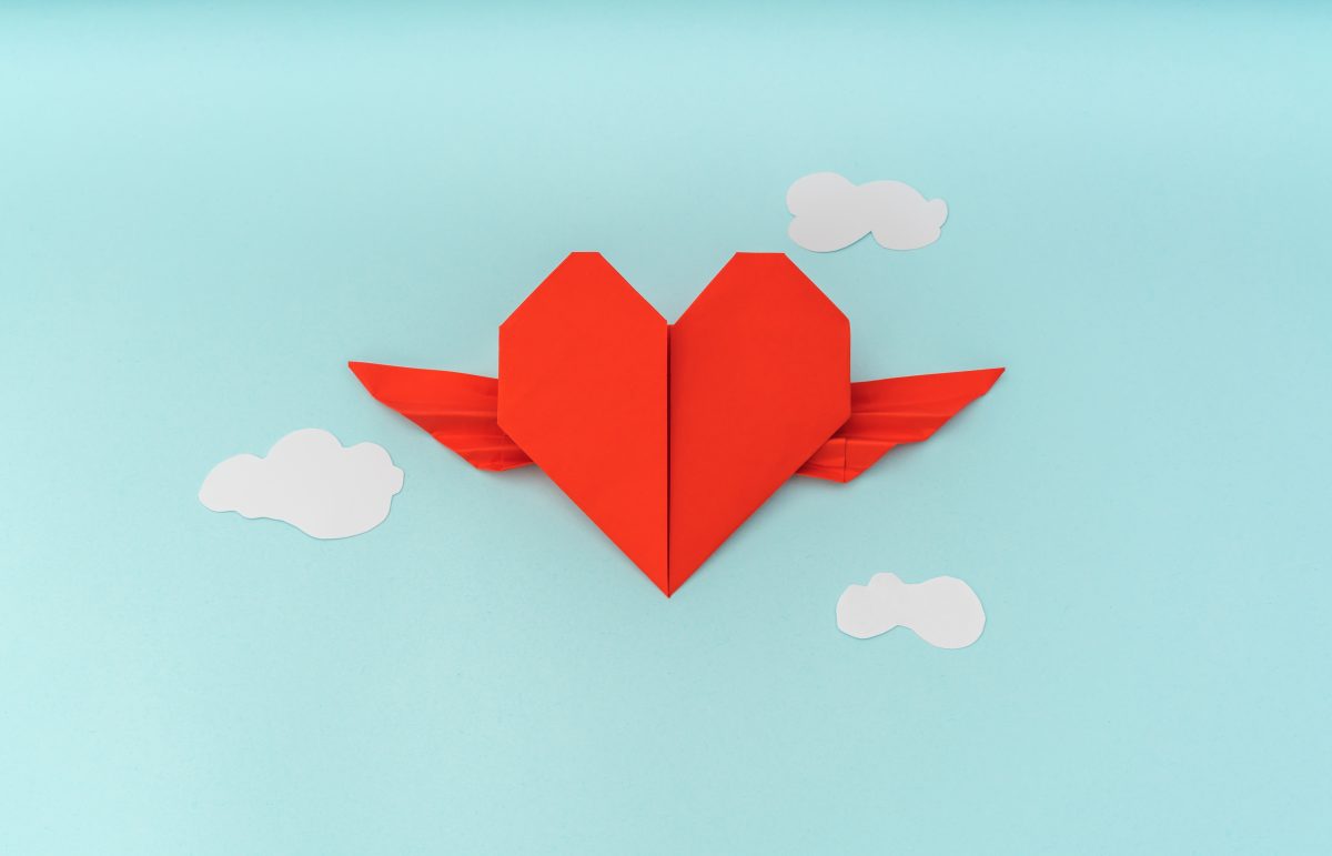 Red+paper+origami+heart+with+wings+and+cloud+on+blue+background