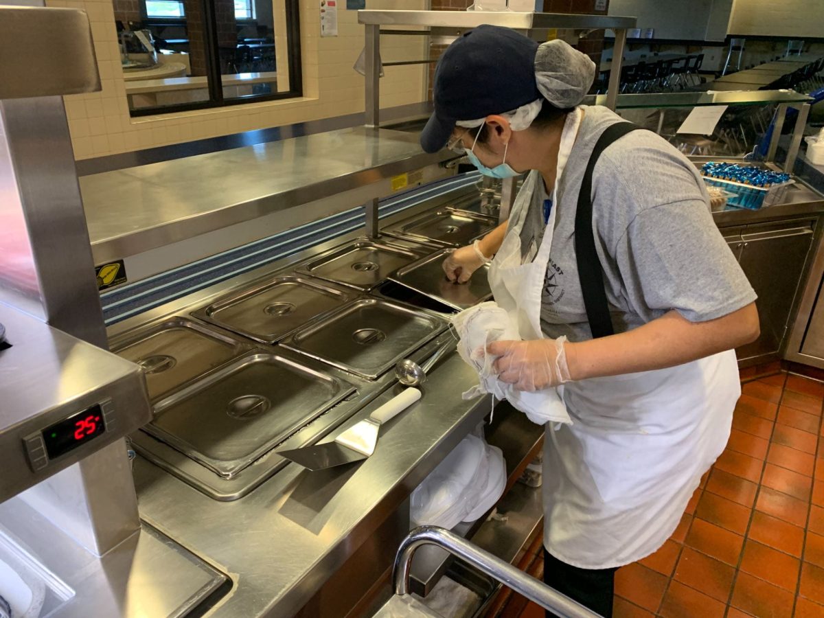 A cafeteria worker, Stacey Coberley helps prepare for enchilada line.