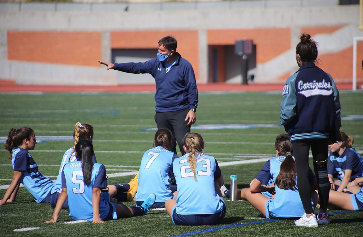 Coach Scott Stone works with his team after an early season game at Heroes Stadium.