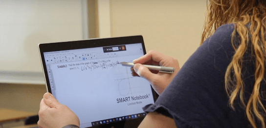 Math teacher Brenda Vanek solves derivatives for her BC calculus class using a touch screen laptop