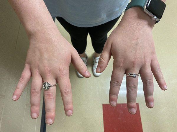Tarbox's hands with silver compass and arrow rings