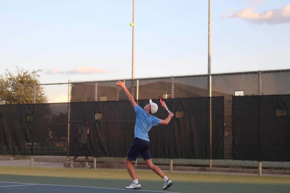 Junior Ethan Pray prepares a serve in a match against Clark. photo by Luis Reyes