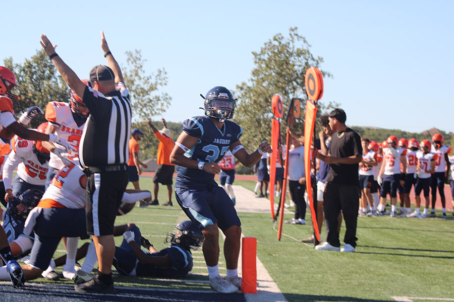 KICKOFF - Football player Arthur Gonzalez is touching the sideline while he runs away from a large mass of players trying to get the ball.